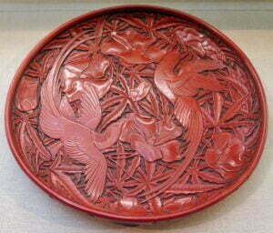 A cinnabar lacquer dish with long-tailed birds and hollyhock, Yuan dynasty, 32.4cm diameter, Metropolitan Museum, New York.
